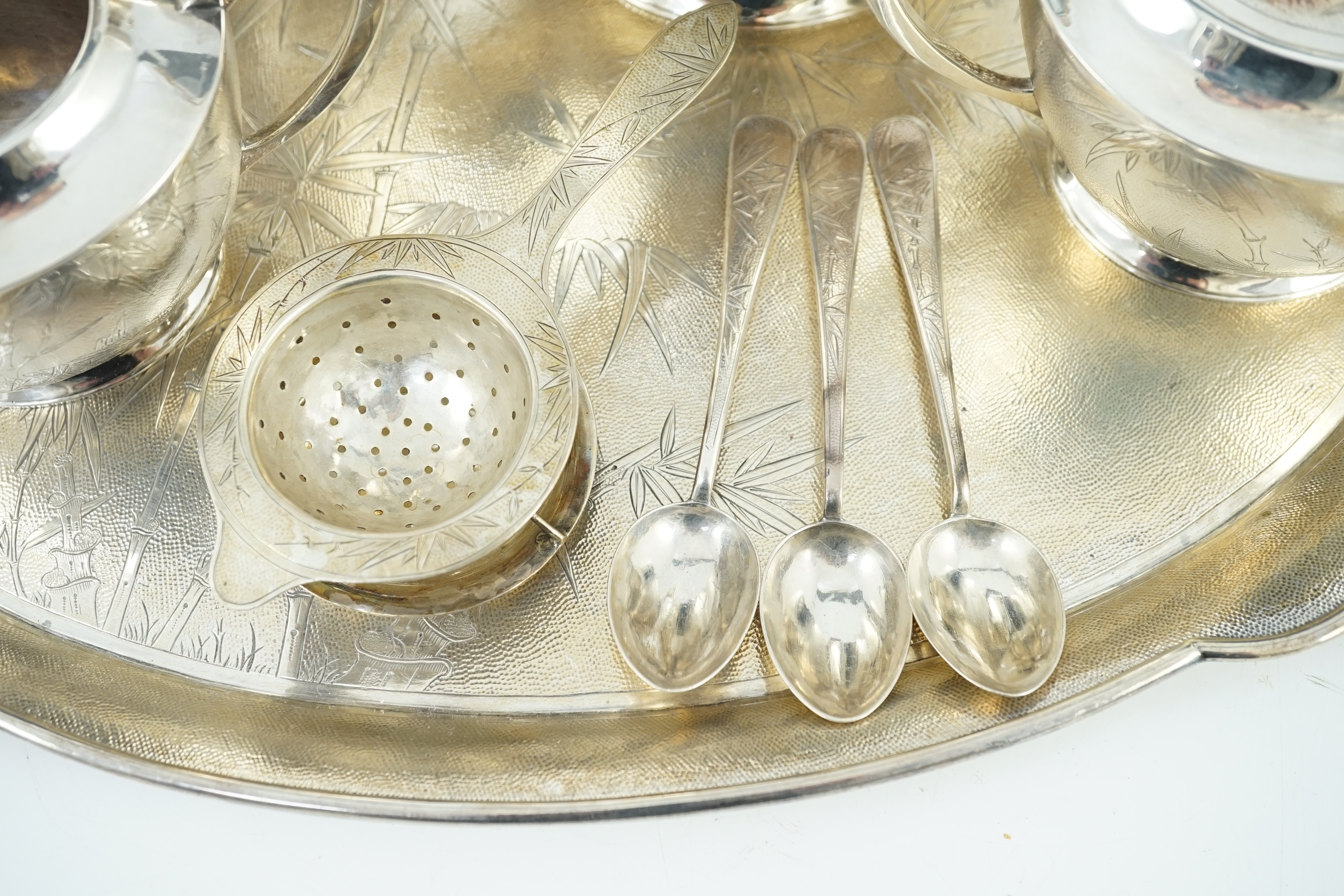 A late 19th/early 20th century Chinese Export sterling silver four piece tea and coffee service and matching oval tea tray, three teaspoons and a tea strainer, by Tack Hing, Hong Kong